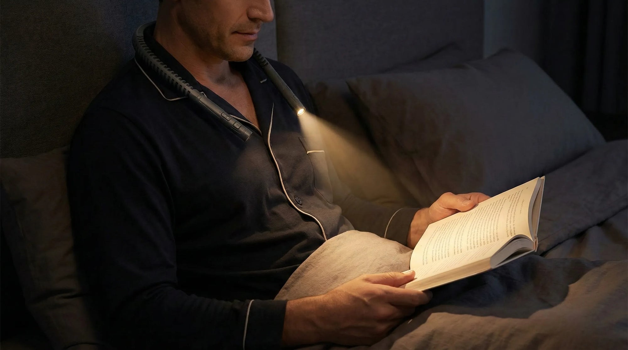 Homme_lisant_au_lit_avec_une_lampe_de_lecture_diffusant_une_lumiere_douce_et_ciblee